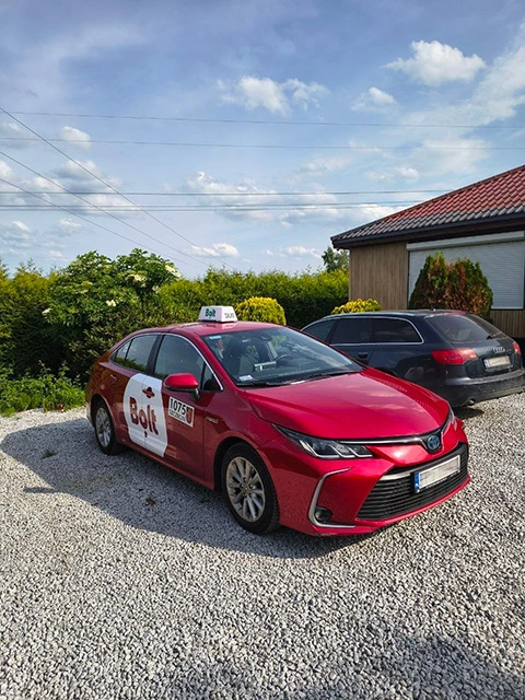 Czerwona Toyota Corolla Hybrid z aplikacją Bolt — samochód Uczciwej Floty w Szczecinie